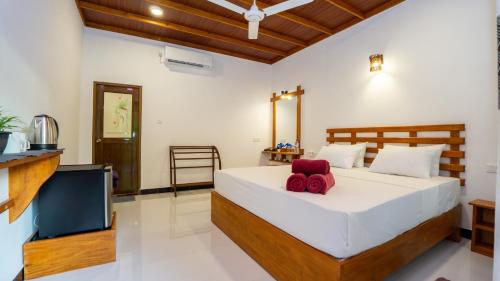 a bedroom with a large bed and a television at Sigiriya Dreamscape Villa in Sigiriya