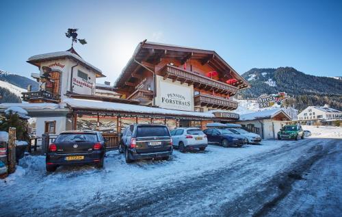 a group of cars parked in front of a building at Ski & Bike Appartements Forsthaus in Saalbach Hinterglemm