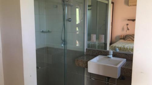 a bathroom with a shower with a sink and a mirror at Lugar Paradisíaco no Cumbuco in Cumbuco