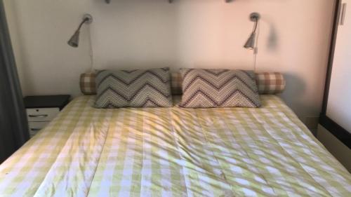 a bed with two pillows on it in a bedroom at Lugar Paradisíaco no Cumbuco in Cumbuco