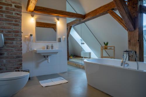 a bathroom with a large white tub and a sink at Penzion Nový Rybník in Obořiště