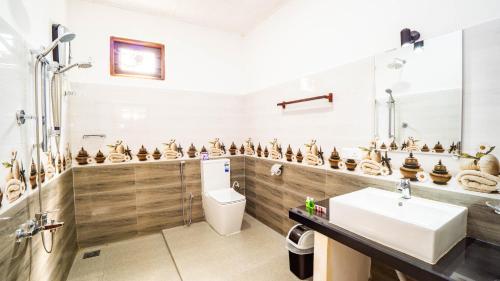 a bathroom with a toilet and a sink at Sigiriya Dreamscape Villa in Sigiriya