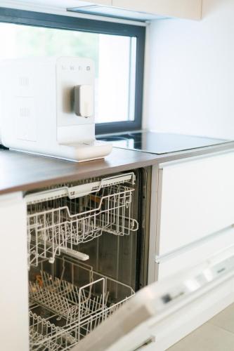 a dishwasher in a kitchen next to a microwave at Wild River 2 in Neporotovo