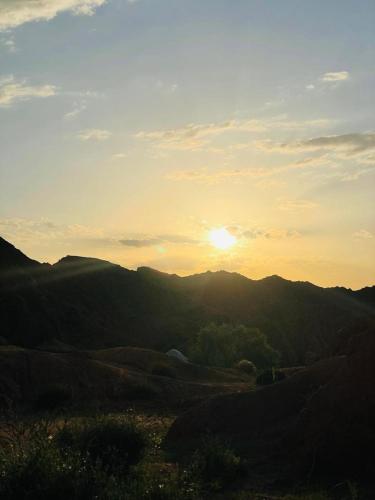 a sunset in the mountains with the sun setting at Ak Bulak in Kurmenty