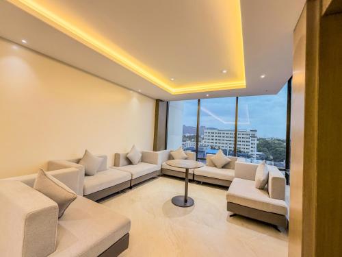 a living room with couches and a large window at Jain Tree by Spree Hotels Vellore in Vellore