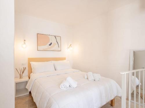a white bedroom with a bed with towels on it at Casa con Vista a POLIGNANO a Mare in Polignano a Mare