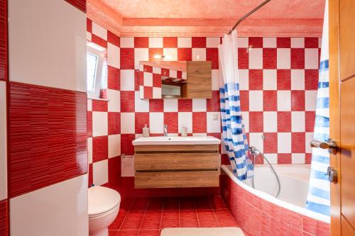 a bathroom with a red and white checkered wall at Christiana's sweet house in Kos