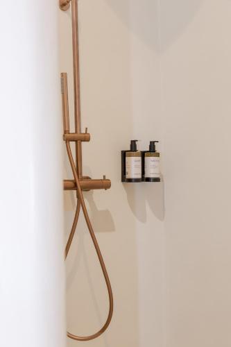 a shower in a bathroom with two bottles on a shelf at Sant Blai Boutique Hotel - Javea in Jávea