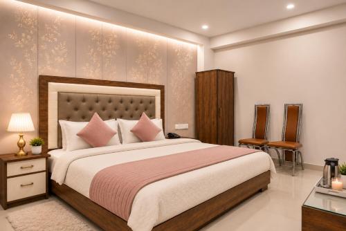 a bedroom with a large bed with pink pillows at Hotel Gold Ston Near Yashoda Hospital & Vaishali Metro in Ghaziabad