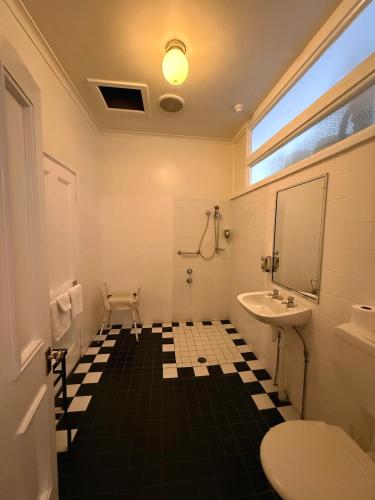 a bathroom with a black and white tiled floor at The Old Vic Hotel in Canowindra