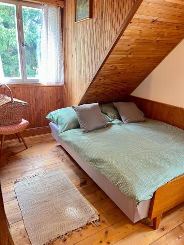 a bed in a room with a wooden wall at Ubytování v Roubence in Modřišice