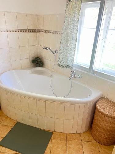 a bath tub in a bathroom with a window at Ubytování v Roubence in Modřišice