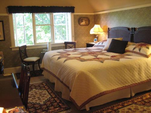 a bedroom with a large bed and a window at Point Grey Guest House in Vancouver