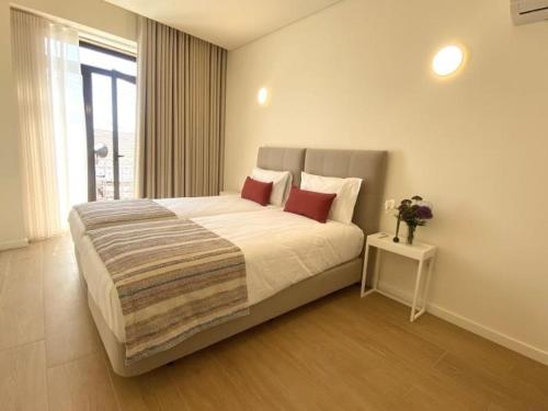 a bedroom with a large bed with red pillows at Casa Mamosteira Apartamento da Eira in Sandim