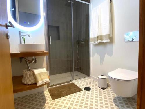 a bathroom with a shower and a toilet and a sink at Casa Mamosteira Apartamento Refugio in Sandim