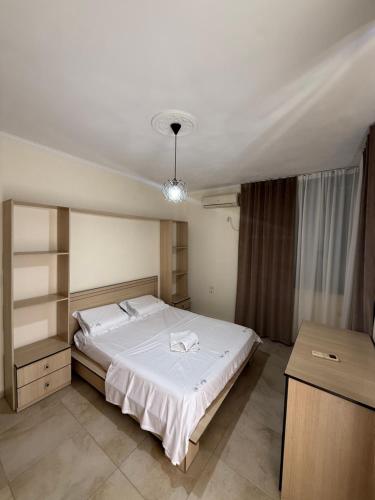 a bedroom with a large white bed in a room at Alfas Beach Apartments in Shëngjin