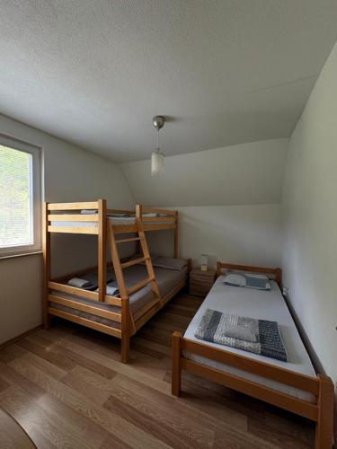 a bedroom with two bunk beds and a window at Villa Pjene in Konjic