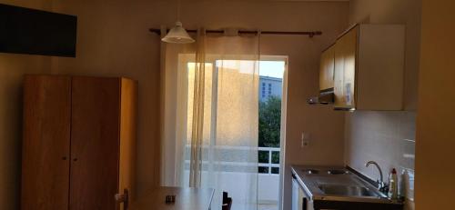 a kitchen with a sink and a shower with a window at K SANTIS STUDIOS in Pefki