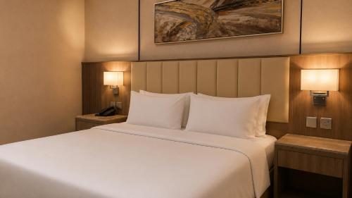 a bedroom with a large bed with white pillows at NARS Plus Serviced Apartments - Al Nuzha in Jeddah