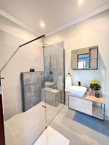 a bathroom with a glass shower and a sink at Die Boord Guesthouse in Crocodile Valley Estates