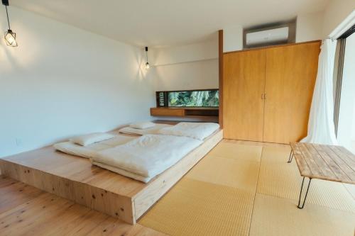 a bedroom with a large bed and a table at MANANI - Vacation STAY 16612v in Nago