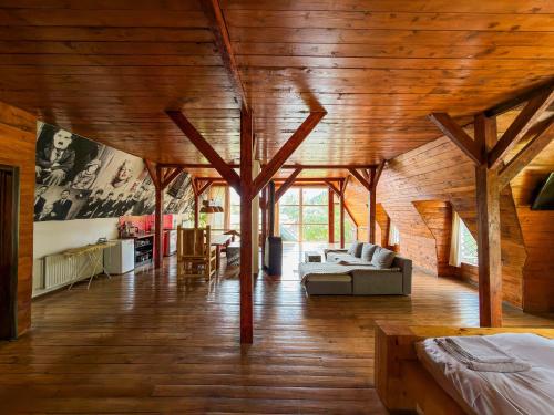 a large room with wooden ceilings and a living room at Salo I Mandry Apartment in Rakhiv