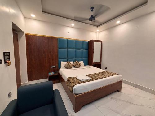 a bedroom with a bed and a blue headboard at hotel wisdom celebration in Motīhāri