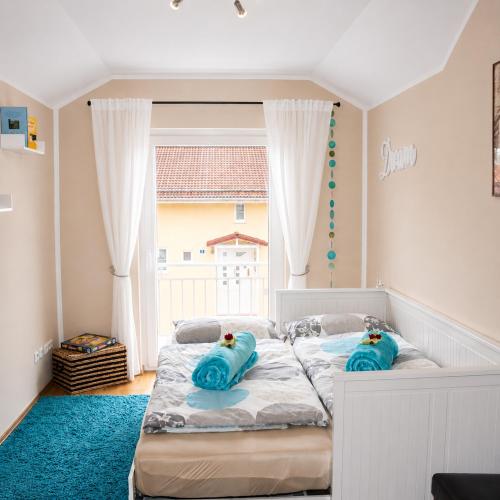 a bedroom with a bed with blue pillows on it at Ferienwohnung Blumäcker Oberbayern in Oberhausen