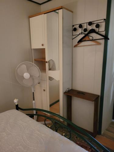 a bedroom with a bed with a fan and a closet at Le nid de la mare in Mervans