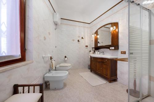 a bathroom with a toilet and a sink and a mirror at Casa Lele in Sarroch