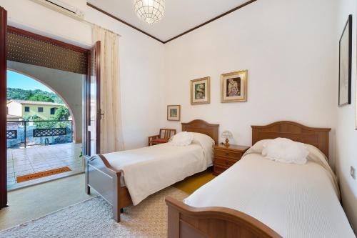 a bedroom with two beds and a balcony at Casa Lele in Sarroch