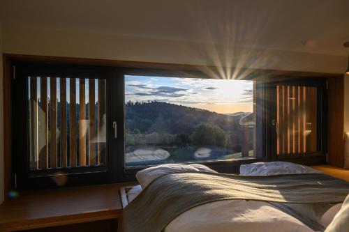 a bedroom with a bed and a large window at Edlgütl - Hideaway in Breitenberg