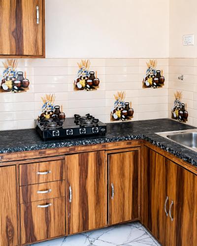 a kitchen with wooden cabinets and a stove top oven at The Nawab's Villa in Mānakpur