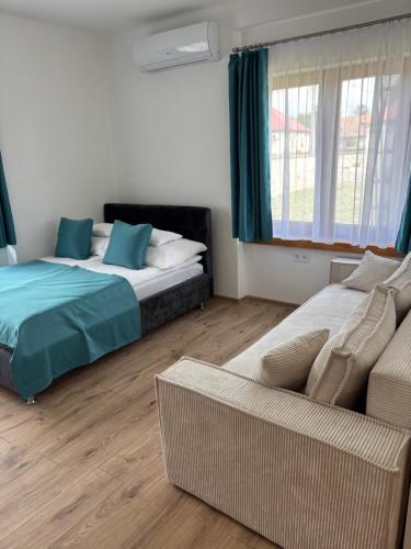 a bedroom with two beds and a couch and a window at WINE NOT Tállya in Tállya