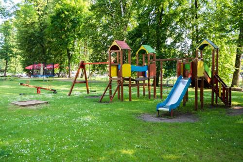 a playground with a slide in a park at Camping ZAMEK C1 in Giżycko