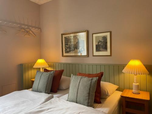 a bedroom with a bed with two lamps on it at Roholtegaard in Faxe
