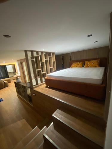 a large bedroom with two beds and a staircase at Bouchareb résidences in Quşaybat al Madyūnī
