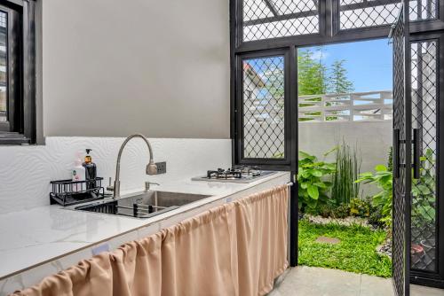 an open kitchen with a sink and a window at Casa Gomes Amuntay in Dasmariñas