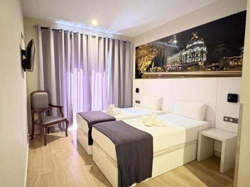 a hotel room with two beds and a chair at CH Olmedo in Madrid