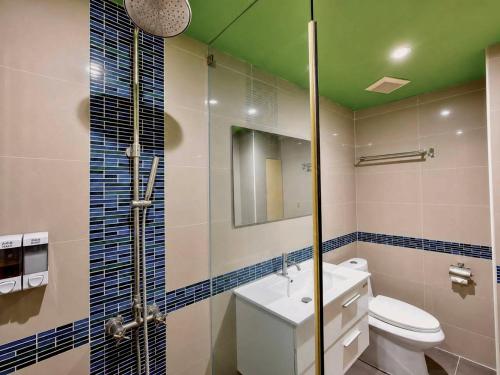 a bathroom with a toilet and a green ceiling at Blue Orchids Hotel in Hat Yai