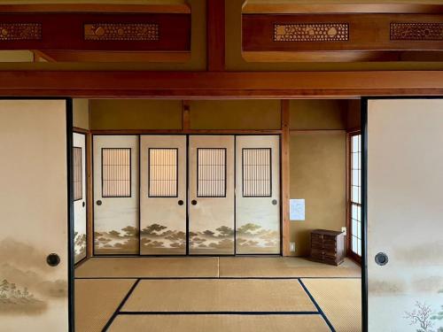 a room with four doors in a building with at 民泊 Vacation rental "Tajimi-jyuku Kitaya" Base for trips to Ghibli Park,Tsumago-juku,Magome-juku in Tajimi