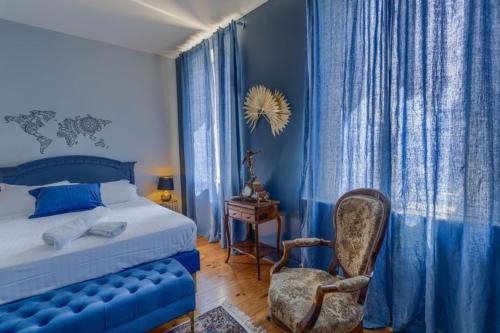a blue bedroom with a bed and a chair at Maison Bacchus 31 in Buzet-sur-Tarn