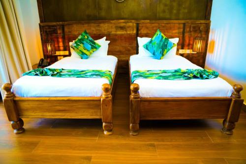 two twin beds sitting next to each other in a room at Noora Resort Bishoftu in Debre Zeyit