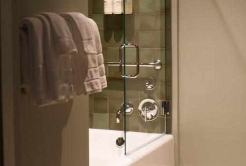 a bathroom with a shower with a sink and towels at The Nickel Hotel in Charleston