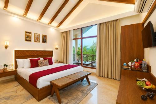 a hotel room with a bed and a large window at Manovan Resort by Eastlynn Experiences, Jim Corbett in Belparāo