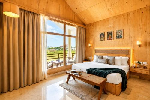 a bedroom with a bed and a large window at Manovan Resort by Eastlynn Experiences, Jim Corbett in Belparāo