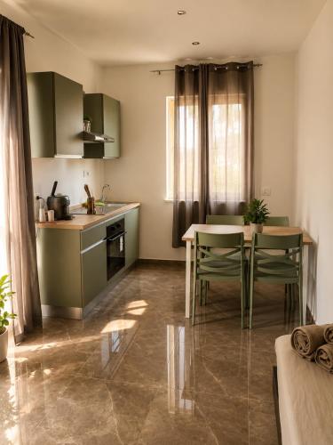 a kitchen with green cabinets and a table and chairs at I Due Moli 2'0 Vibo Marina in Vibo Valentia Marina