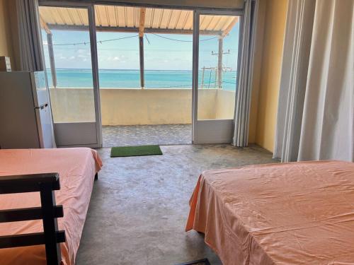 a bedroom with two beds and a view of the ocean at EcoDream Lodge in Port Mathurin