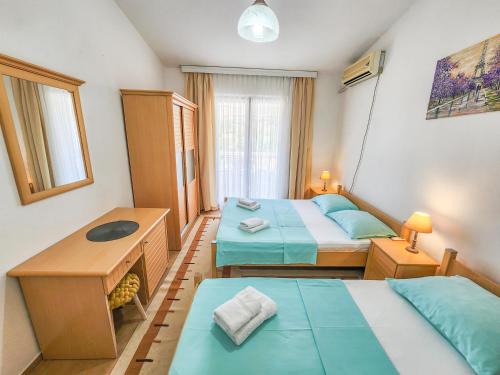 a small room with two beds and a table at Guesthouse Elsa in Ulcinj