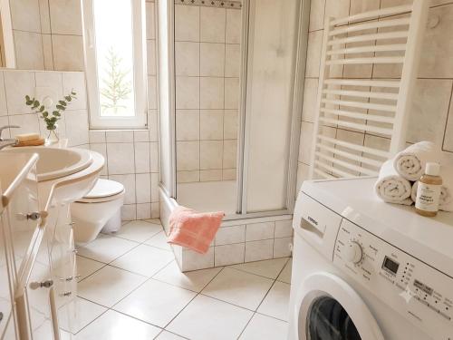 a white bathroom with a washing machine and a sink at Ein Zuhause auf Zeit in Osterburg